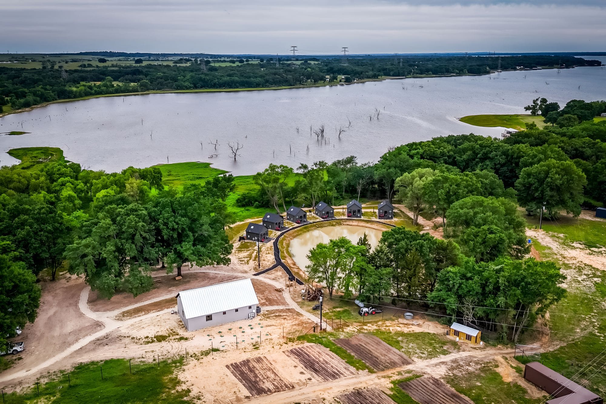 Aerial view of the property, the barn and the garden beds beside Lake Limestone