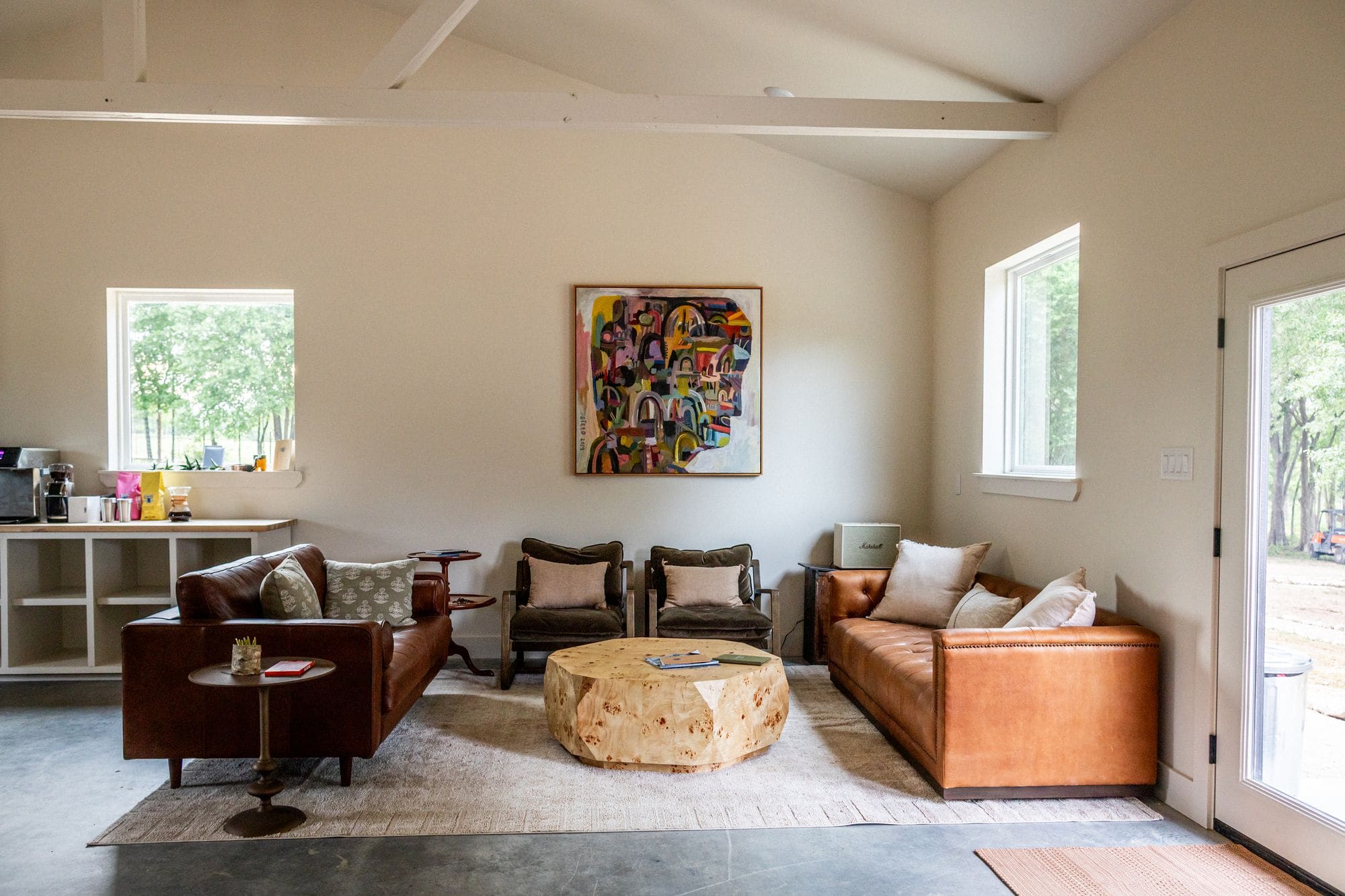 Commons barn lounge with leather sofas, a burl-wood table and colorful artwork