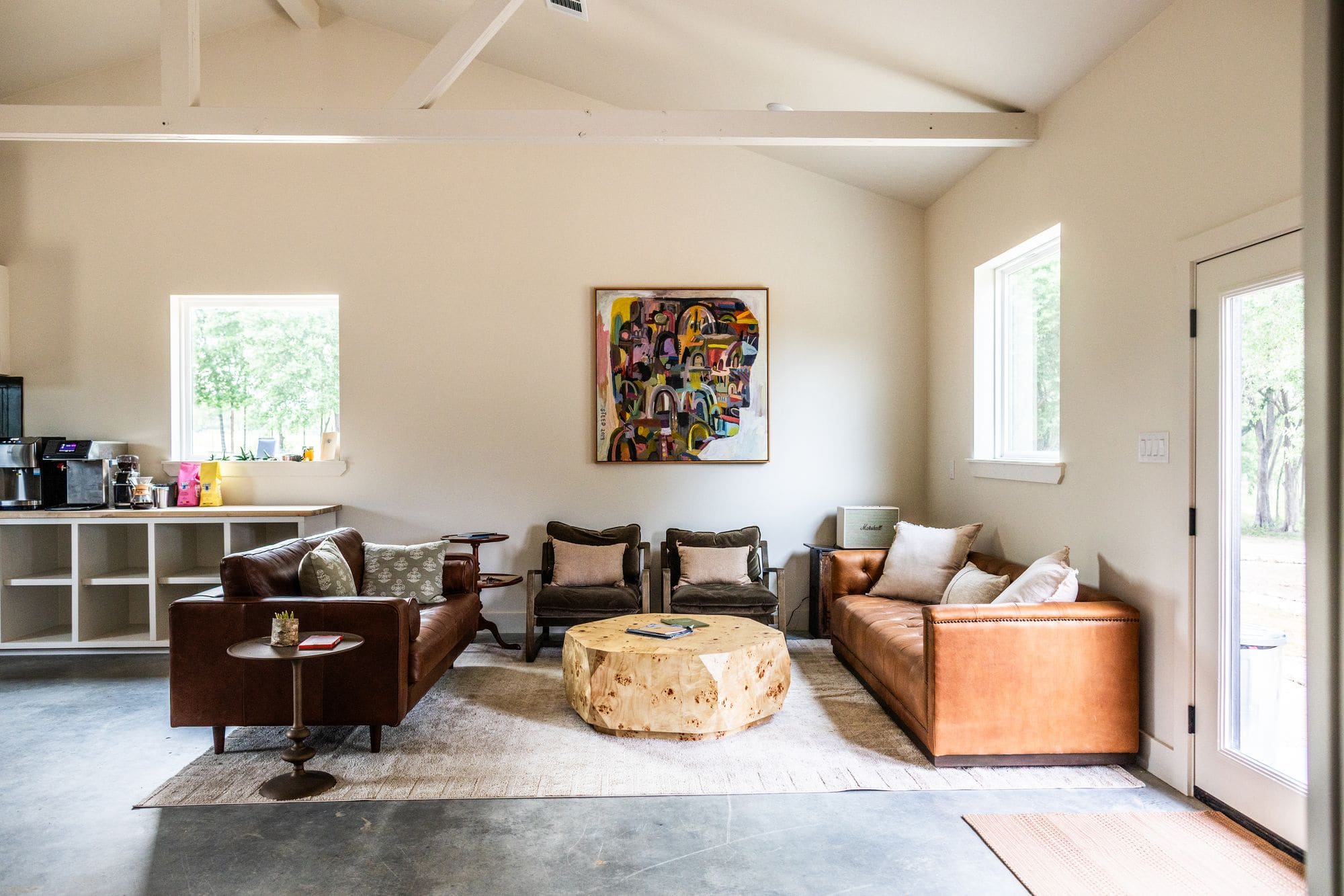 Commons barn lounge with tan and brown leather sofas and French doors