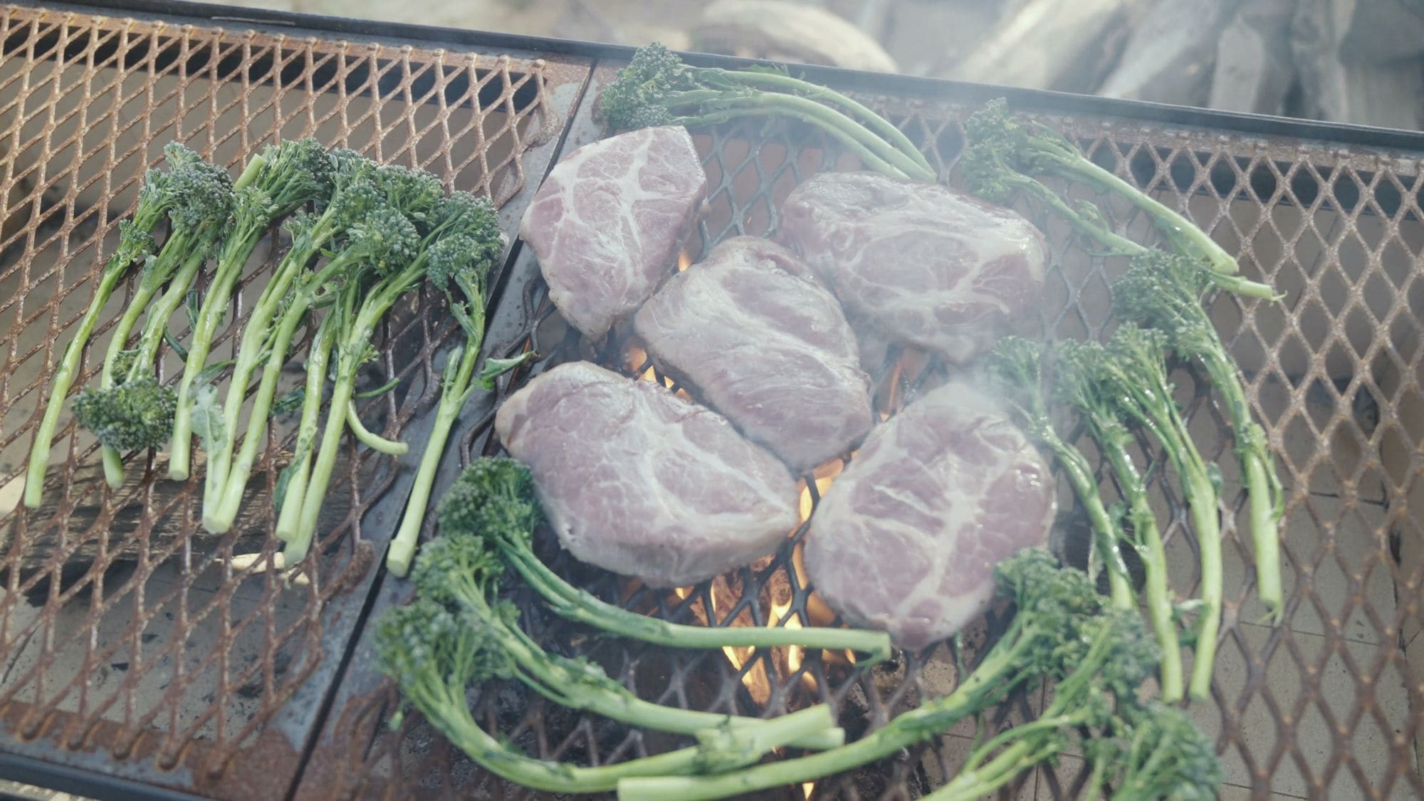 Steaks and broccolini on the grill grate