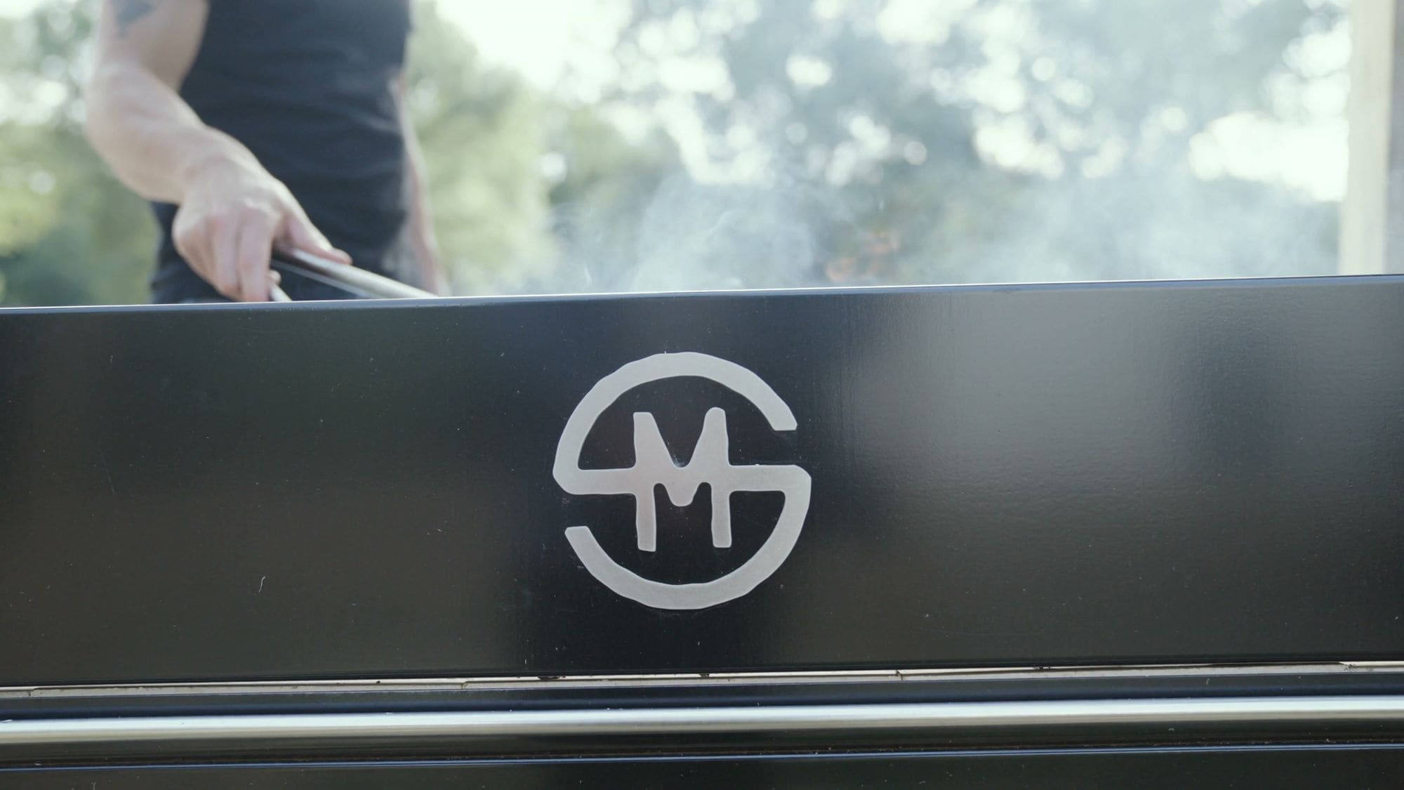 Tending the outdoor grill with tongs